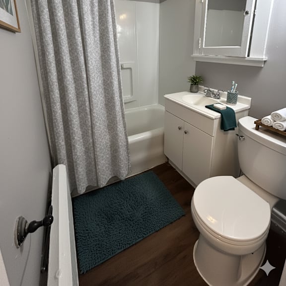 a white bathroom with a blue rug on the floor.