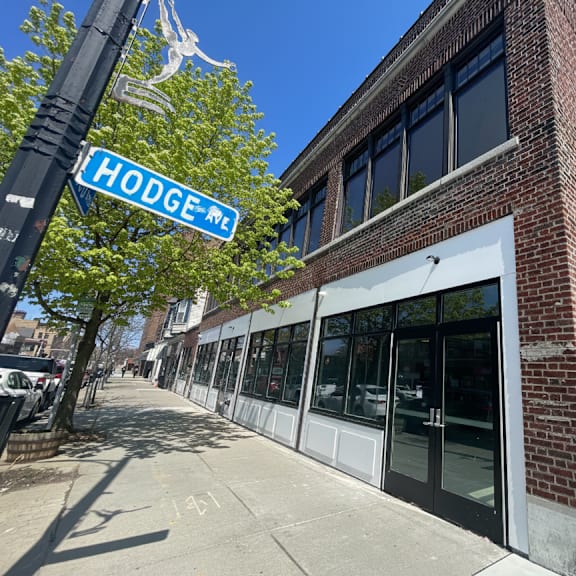 a street view of a building with a sign that says hodge me.