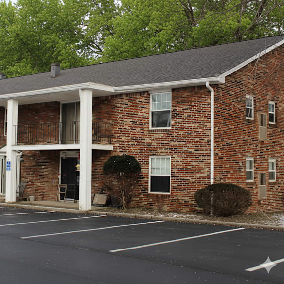 a brick building with a parking lot in front.
