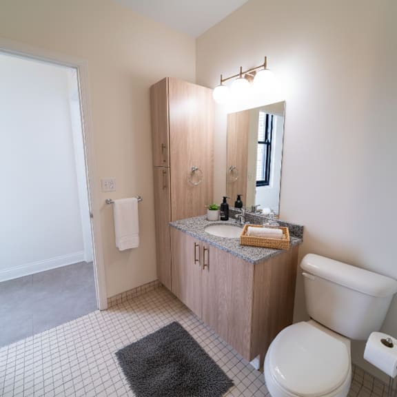 a bathroom with a toilet, sink, and mirror.