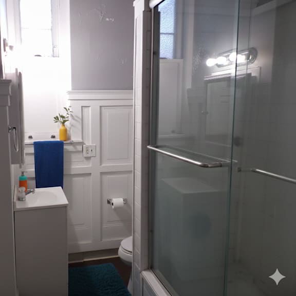 a bathroom with a white cabinet and a blue vase on top of it.