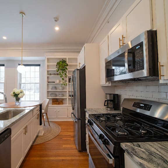 a kitchen with a black stove top oven and a black microwave above it.