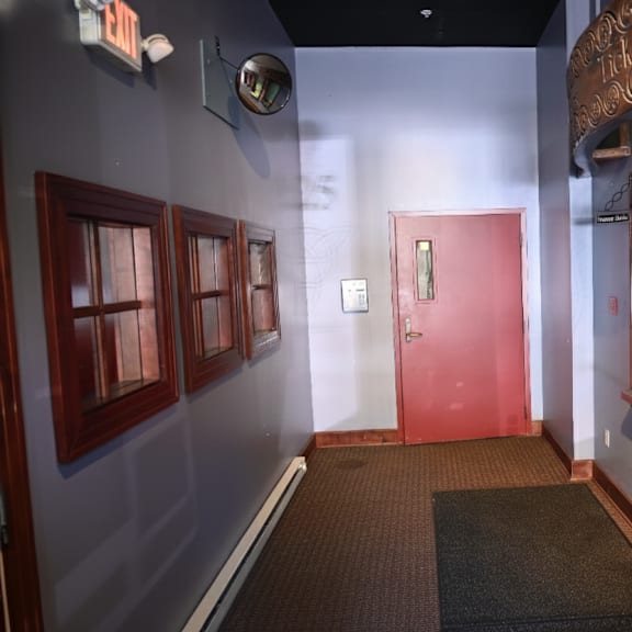 a hallway with a red door and a sign on the wall.