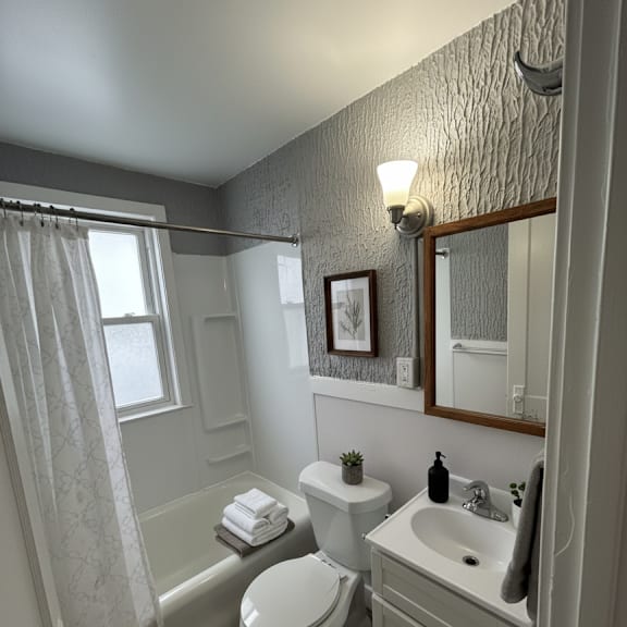 a bathroom with a toilet, sink, and bathtub.