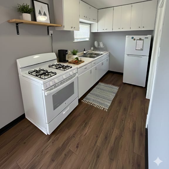 a small kitchen with a white stove and wooden floors.