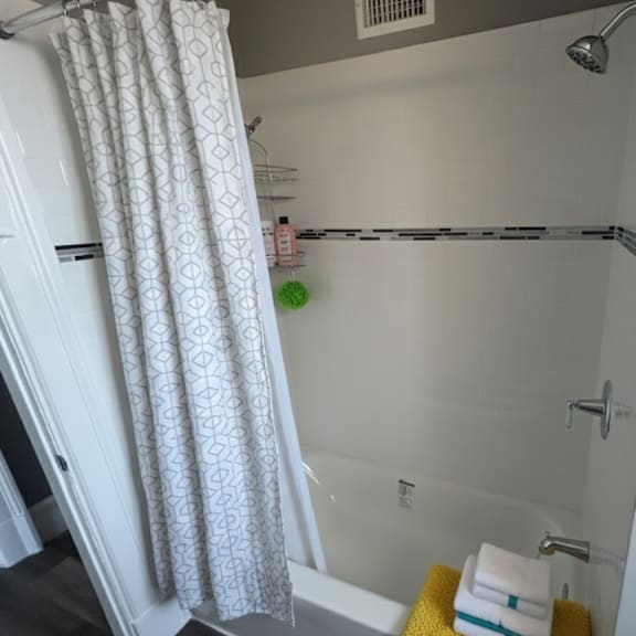 a white bathroom with a white shower curtain and a white bathtub.