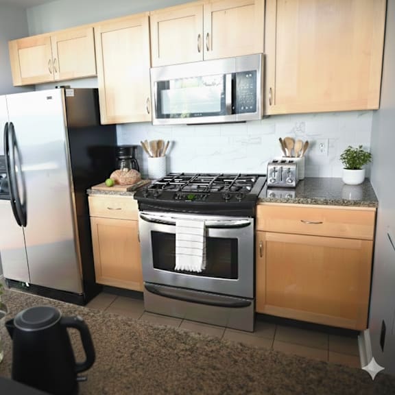 a kitchen with a refrigerator, oven, and microwave.