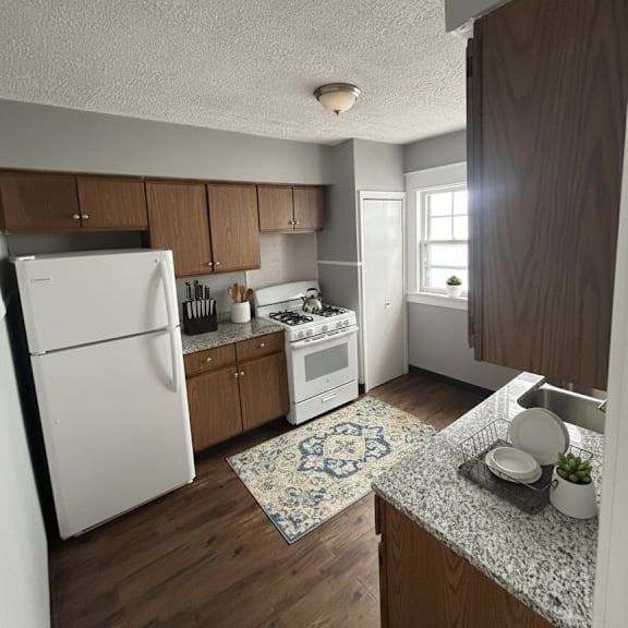 a kitchen with a white refrigerator and wooden cabinets.