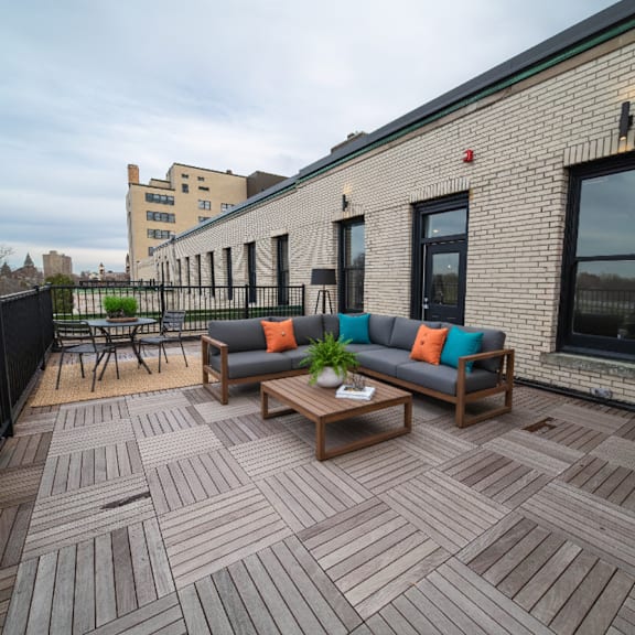 a wooden deck with a couch and chairs.