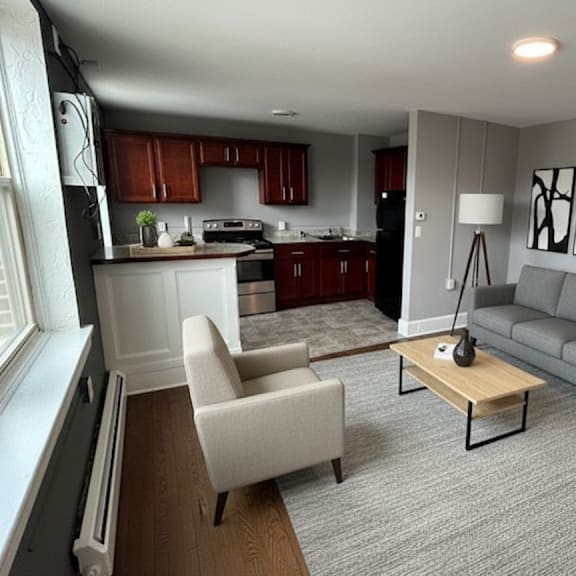 a modern living room with a grey couch, a wooden coffee table, and a window.
