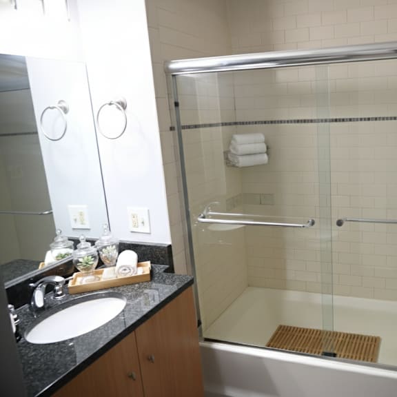 a bathroom with a glass shower door and a white towel hanging on the shower rod.