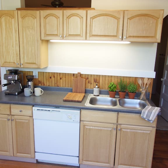 a kitchen with wooden cabinets and a white dishwasher.
