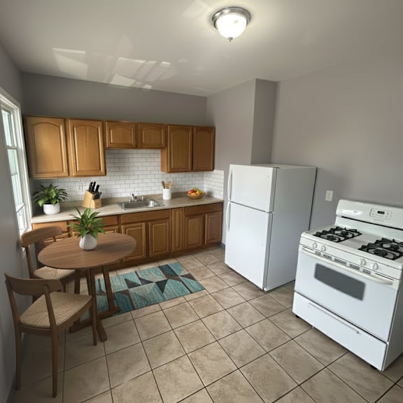 a kitchen with white appliances and wooden cabinets.
