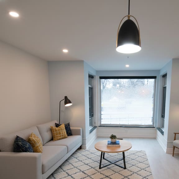 a living room with a white couch, a coffee table, and a fireplace.