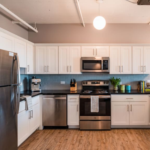 a kitchen with white cabinets and stainless steel appliances.