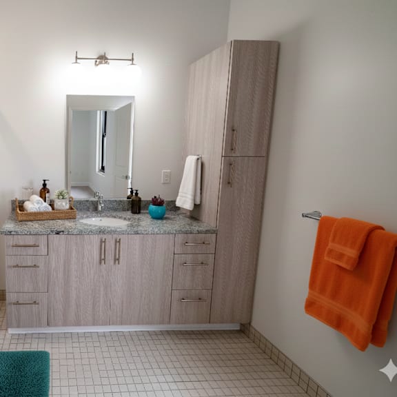 a bathroom with a glass shower stall, a sink, and a towel rack.