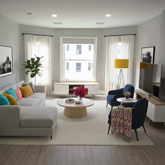 a living room with a white couch, a coffee table, and a potted plant.