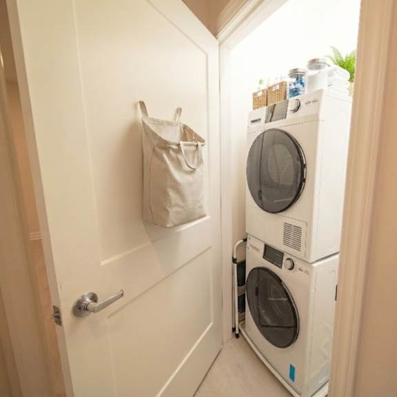 a white washing machine and dryer stacked on top of each other in a small laundry room.