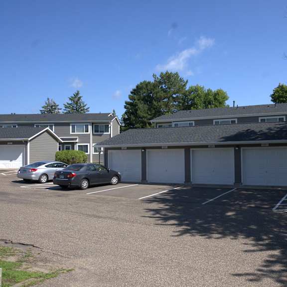 a parking lot with cars and a building in the background.