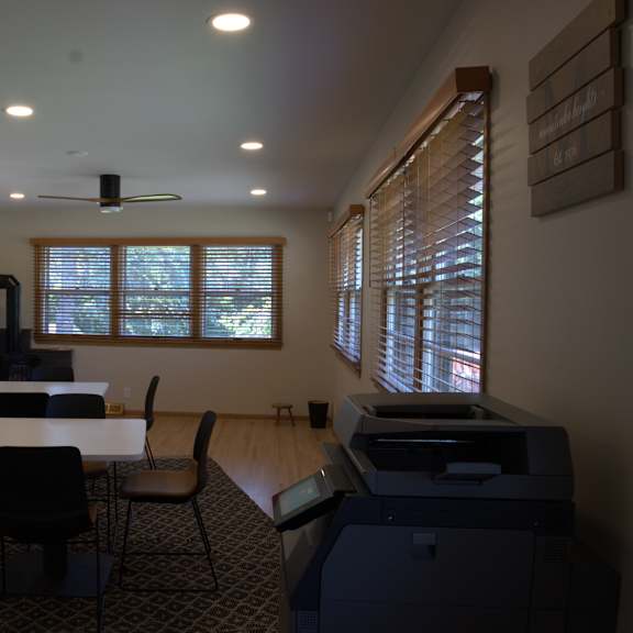 a room with a table, chairs, and a printer.