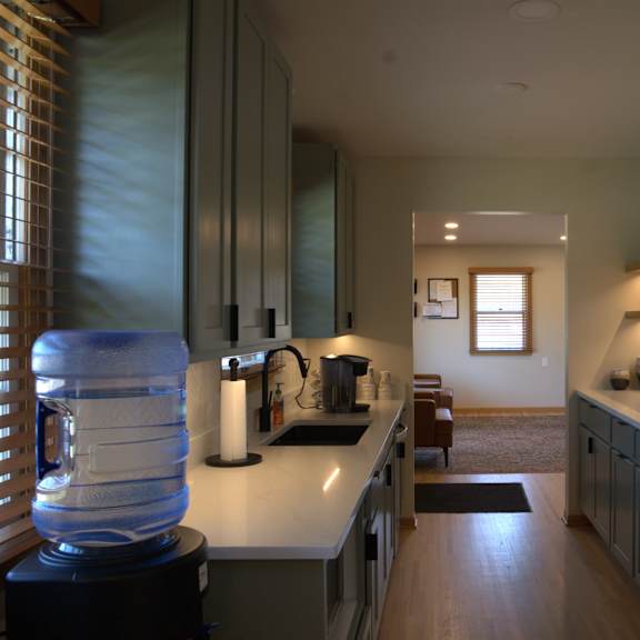 a kitchen with a white counter top and a water cooler.