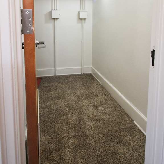 a nice size closet with a carpeted floor and white walls