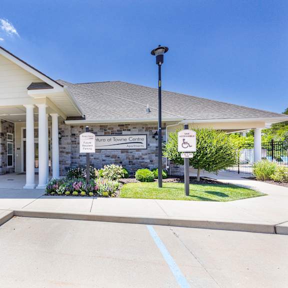 the front entrance of a white building with columns and a porch at aventura at towne centre, missouri, 63011