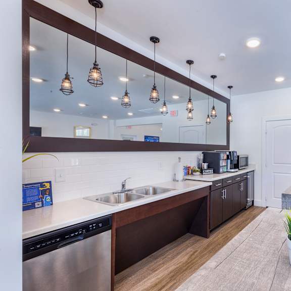 a kitchen with stainless steel appliances and a communal table at aventura at towne centre, ellisville