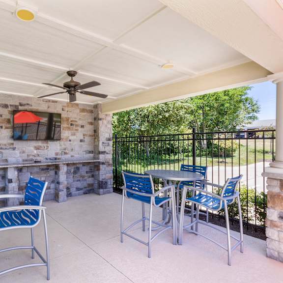 a patio with tables and chairs and a tv on the wall at aventura at towne centre, missouri, 63011