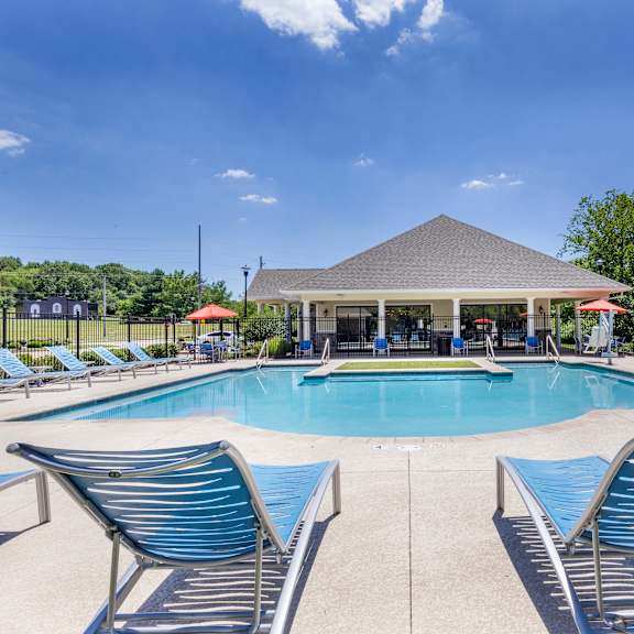 a swimming pool with blue chairs and a pavilion next to a resort style pool at aventura at towne centre, ellisville, missouri
