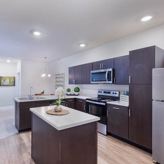 a kitchen with dark cabinets and a white counter top at aventura at towne centre, missouri, 63011