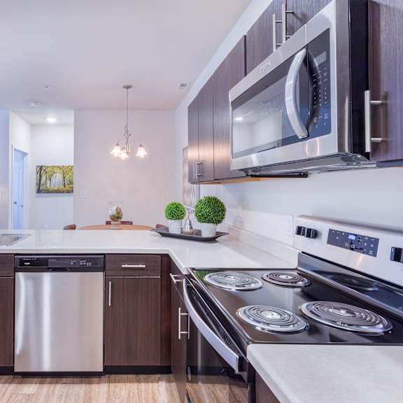 a kitchen with stainless steel appliances and a stove and a microwave at aventura at towne centre, ellisville, mo