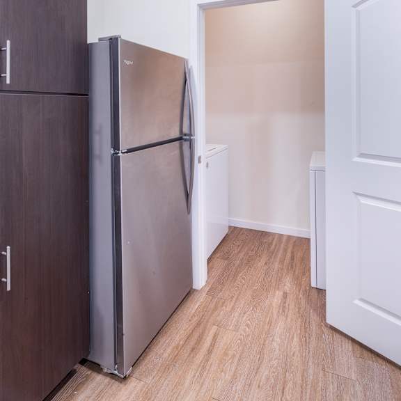 a kitchen with a refrigerator and a door to a closet at aventura at towne centre, ellisville, mo