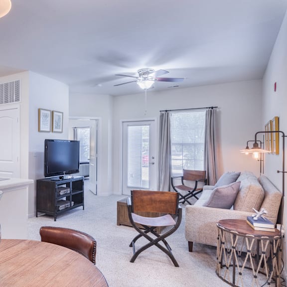 a living room with a dining room table and a television at aventura at towne centre, ellisville, mo, 63011