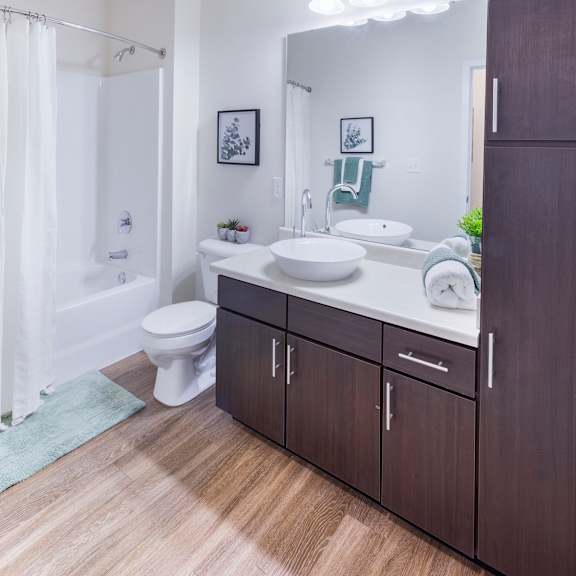 a bathroom with a toilet sink and shower and a mirror at aventura at towne centre, missouri