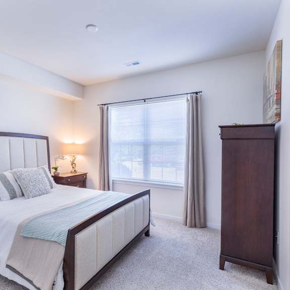 a bedroom with a bed and a dresser and a window at aventura at towne centre, ellisville, 63011
