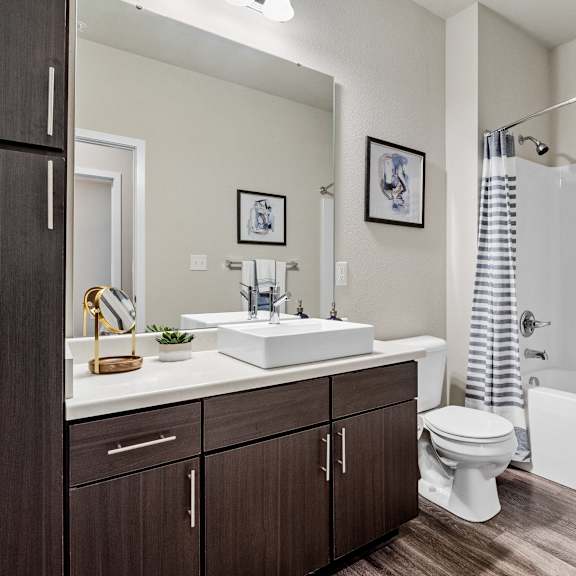 a bathroom with a toilet sink and shower and a mirror  at aventura at wentzville, missouri