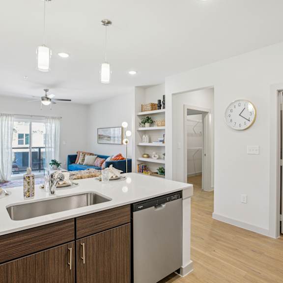 Thumbnail 12 of 37 A kitchen with a white counter top and wooden cabinets at ThreeTwenty at the Vybe Apartments, Kyle, 78640