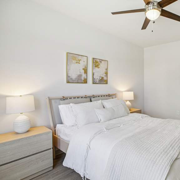 Thumbnail 26 of 37 A bedroom with a bed, nightstand, and a ceiling fan. at ThreeTwenty at the Vybe Apartments, Kyle, TX, 78640