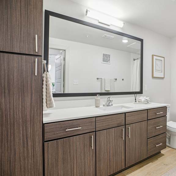 Thumbnail 34 of 37 A bathroom with a white toilet, a sink, and a bathtub at ThreeTwenty at the Vybe Apartments, Kyle, TX, 78640
