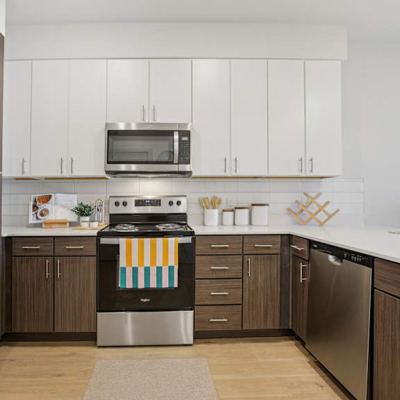Thumbnail 11 of 23 A modern kitchen with a stainless steel refrigerator and a dishwasher at ThreeTwenty at the Vybe Apartments, Kyle