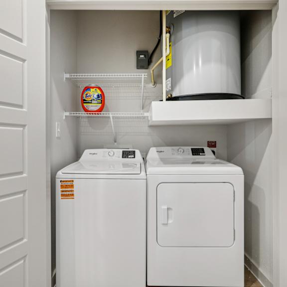 Thumbnail 14 of 23 A small laundry room with a washer and dryer at ThreeTwenty at the Vybe Apartments, Kyle, Texas