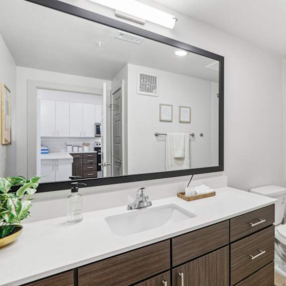 Thumbnail 15 of 23 A bathroom with a white sink and toilet. at ThreeTwenty at the Vybe Apartments, Kyle, TX, 78640