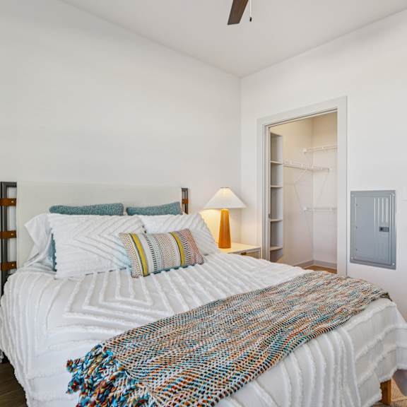 Thumbnail 22 of 23 A bedroom with a large bed and a ceiling fan at ThreeTwenty at the Vybe Apartments, Kyle, 78640