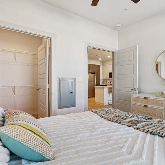 Thumbnail 23 of 23 A bedroom with a bed, dresser, and mirror. at ThreeTwenty at the Vybe Apartments, Texas, 78640
