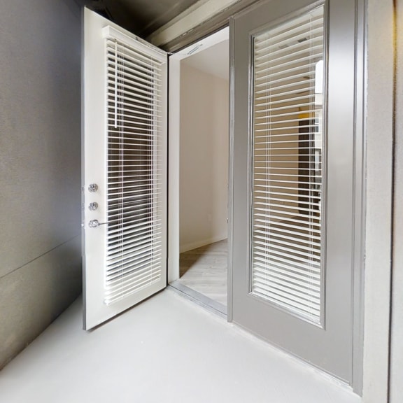 Thumbnail 6 of 9 Entry door with white frame and integrated blinds at Bridge at Windsor Park Apartments, Austin, TX