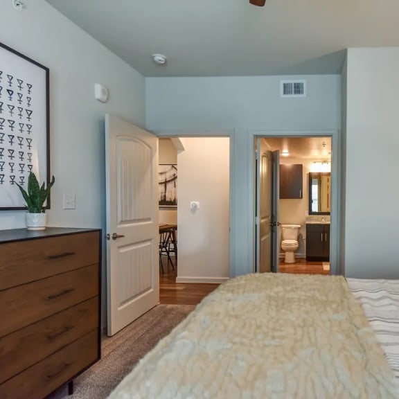 Thumbnail 6 of 11 Bedroom with ensuite bathroom and hardwood flooring at High Point Preserve Apartments, Texas