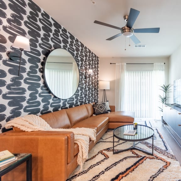 Thumbnail 2 of 15 a living room with a brown couch and a black and white accent wall at Three Hills, Austin, TX 78747