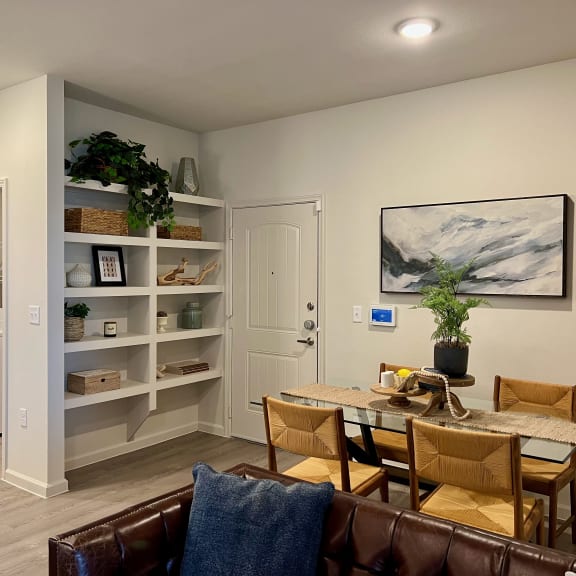 Thumbnail 4 of 16 Dining space with natural wood furniture and wall art 1 at High Point Preserve Apartments, Austin, Texas