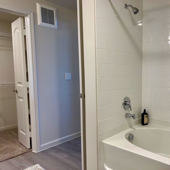 Thumbnail 15 of 16 White tile tub shower with builtin soap ledge at High Point Preserve Apartments, Texas